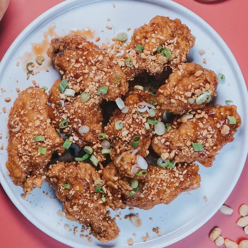Crispy WingNow chicken wings, glazed with sauce, topped with chopped peanuts and green onions.